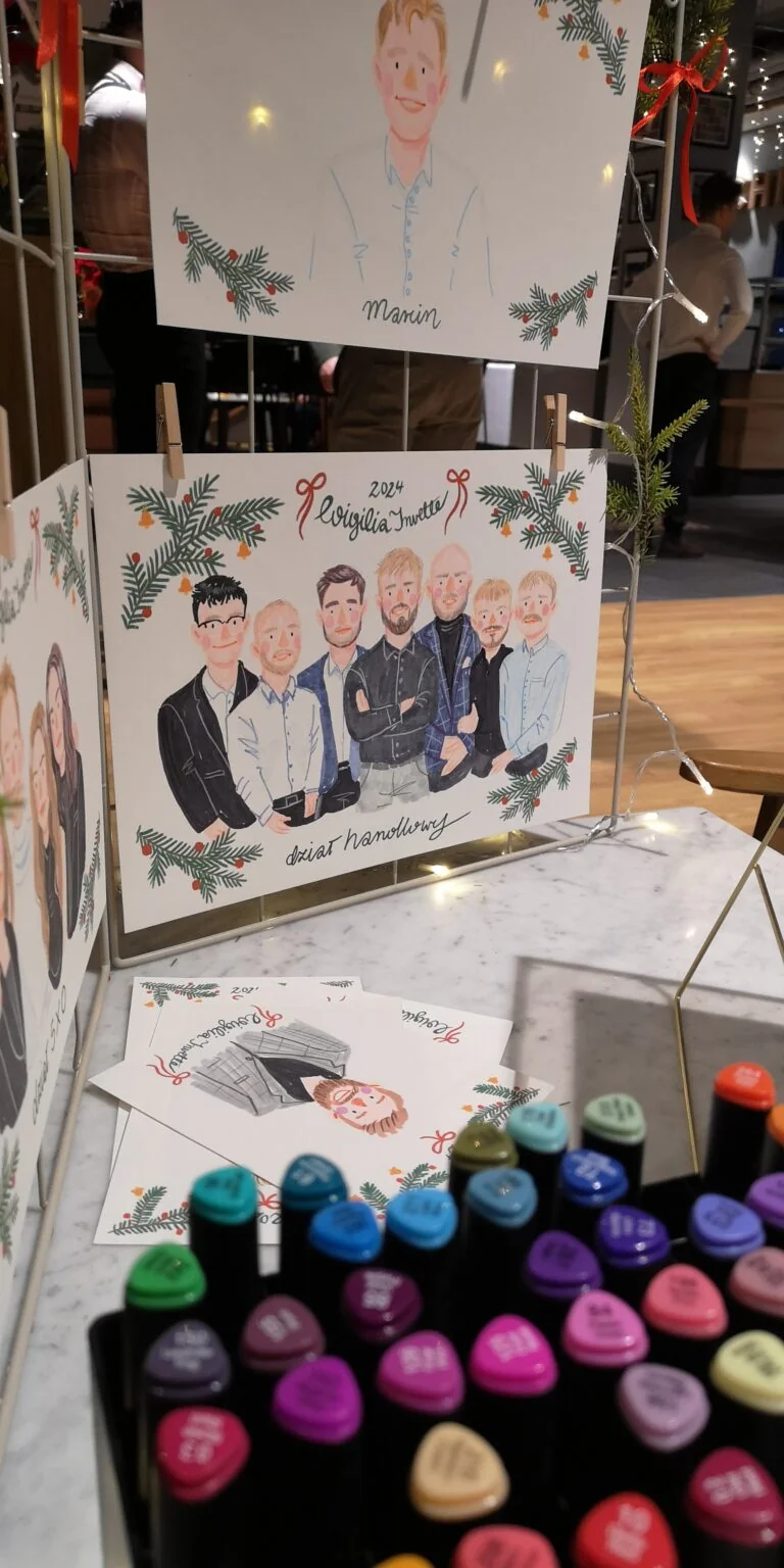 Live painting na evencie firmowym - ilustrowane portrety zespołu na stojaku i markery na stole